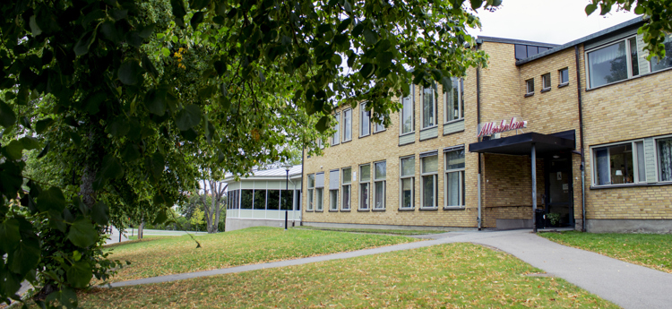 Tegelbyggnad. Entrén till Alléskolan i Åtvidaberg.